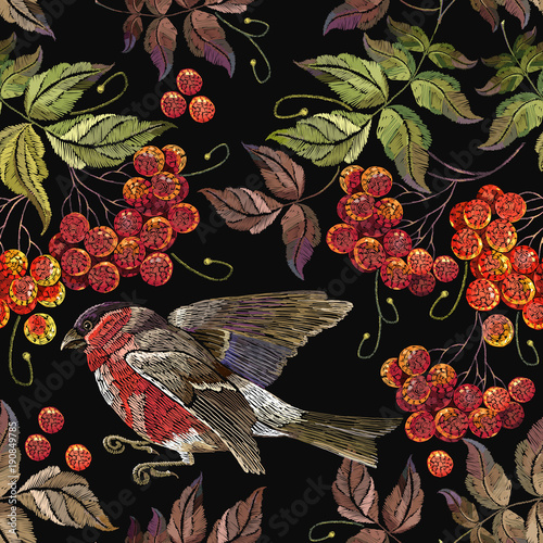 Bullfinch a branch of mountain ash berry pattern. Embroidery bird sitting on mountain ash branch seamless pattern. Fashionable template for design of clothes