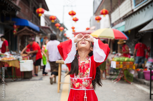 Young chinese girl in red dress posing for Lunar new year celebration