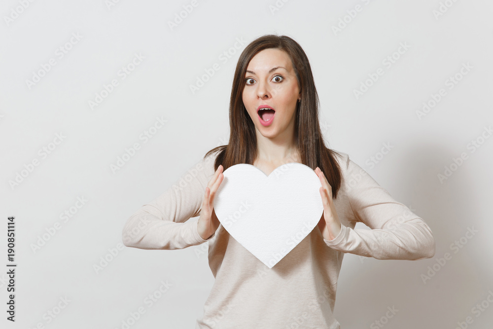 Pretty young cheerful woman holding big white heart in hands isolated on white background. Copy space for advertisement. With place for text. St. Valentine's Day or International Women's Day concept. Pretty young cheerful woman holding big white heart in hands isolated on white background. Copy space for advertisement. With place for text. St. Valentine's Day or International Women's Day concept.