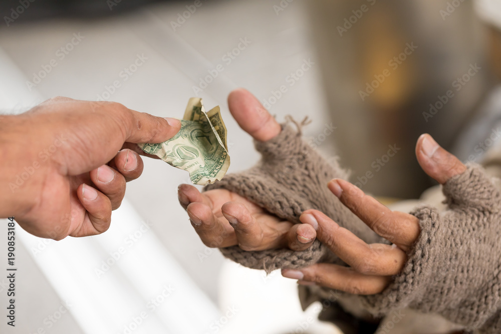 Man's holdind money gives money to a homeless person. Senior person hands begging for money