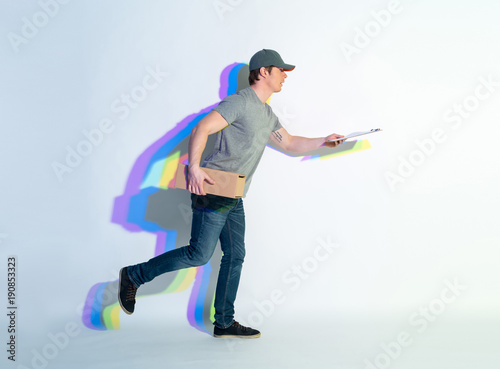 Full length side view surprised man going with parcel and documents in arm. Painted reflection situating near him. Dispatch concept