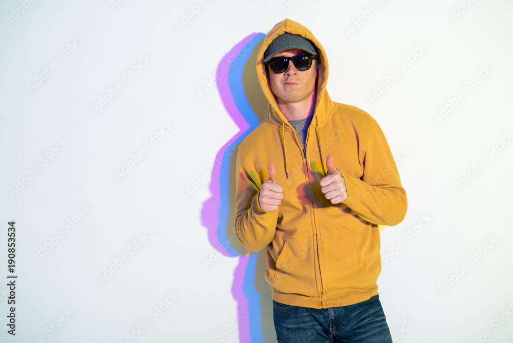 Portrait of assertive male gesticulating arms while showing ok sign. Confidence concept. Copy space