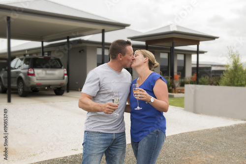 young happy and beautiful couple in love drinking champagne or wine having sweet toast celebrating anniversary or valentines day outdoors