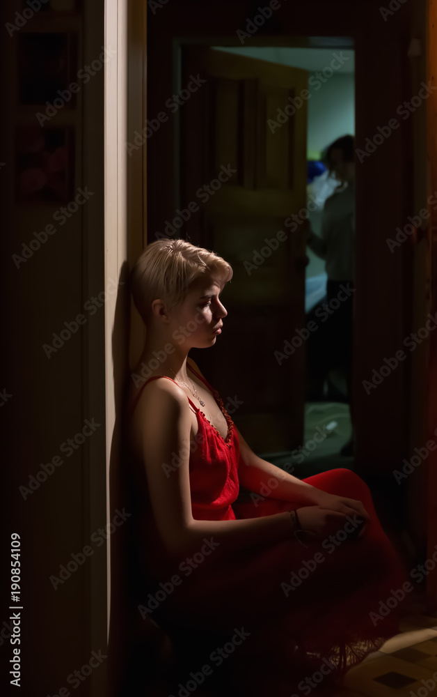 Fototapeta premium The girl in the red dress at the door