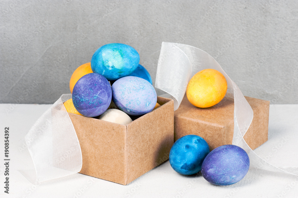 Colored easter eggs in the craft box with light ribbon Colored easter eggs in the craft box with light ribbon