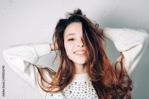 Close up shot of stylish young woman smiling against white background. Beautiful female model with copy space.