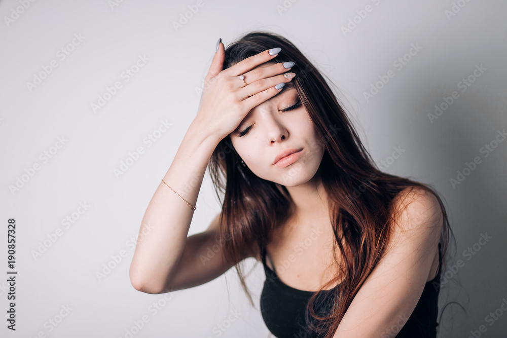 Woman with hard headache holding hands on head on whit background. Woman with hard headache holding hands on head on whit background.
