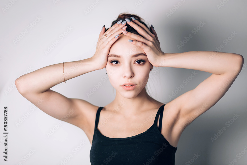 Closeup portrait of a serious lady with smoky eye makeup. Woman hands holding her head on both sides. Closeup portrait of a serious lady with smoky eye makeup. Woman hands holding her head on both sides.