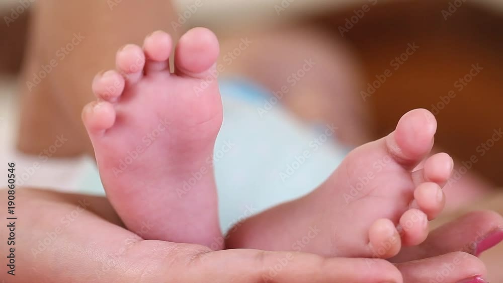 Newborn Baby's feet.Mother holding newborn baby legs,legs massage Newborn Baby's feet.Mother holding newborn baby legs,legs massage