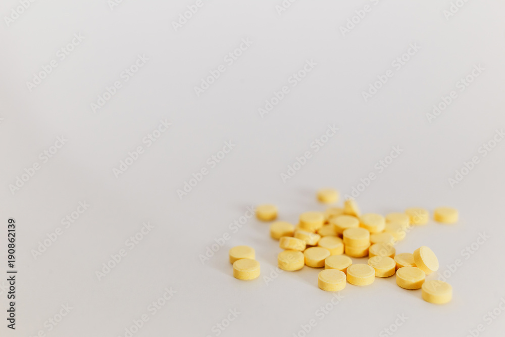lots of little yellow pills on white background. medicine lots of little yellow pills on white background. medicine