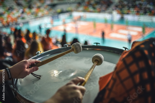 Canvastavla Drum of supporters  and volleyball court in the background.