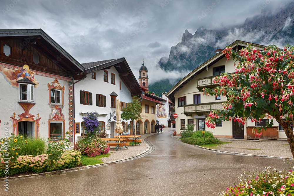 Typical bavarian houses with mountain top view in clouds, Im Gries street, Mittenwald, Germany