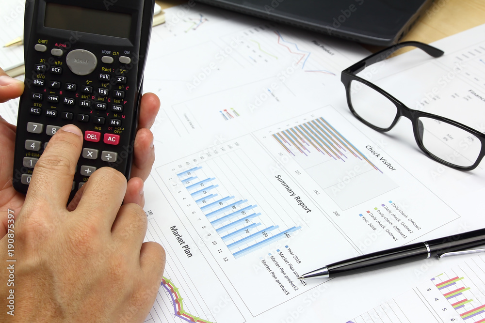 Businessman using calculator with business graph Businessman using calculator with business graph