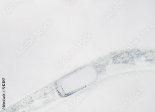 Top view on  snowy car on the parkplace at the end winter. Seasonal Snowfall photo