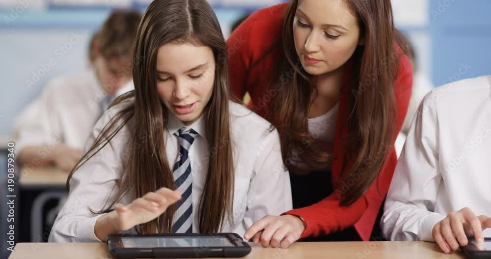 4k, Teacher helping student with digital tablet in classroom. 4k, Teacher helping student with digital tablet in classroom.