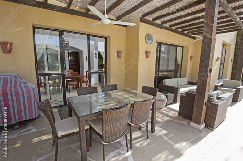 Fototapeta Naklejka Na Ścianę i Meble -  Patio area with sofa and dining table at a luxury tropical holiday villa resort