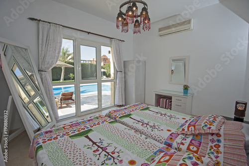 Interior design of bedroom in villa with garden swimming pool view