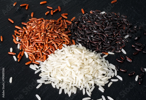 Jasmine rice, Red rice, Black rice on black stone background photo