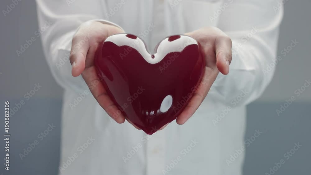mans showing to camera a heart jelly-like in his hands. Open heart concept mans showing to camera a heart jelly-like in his hands. Open heart concept