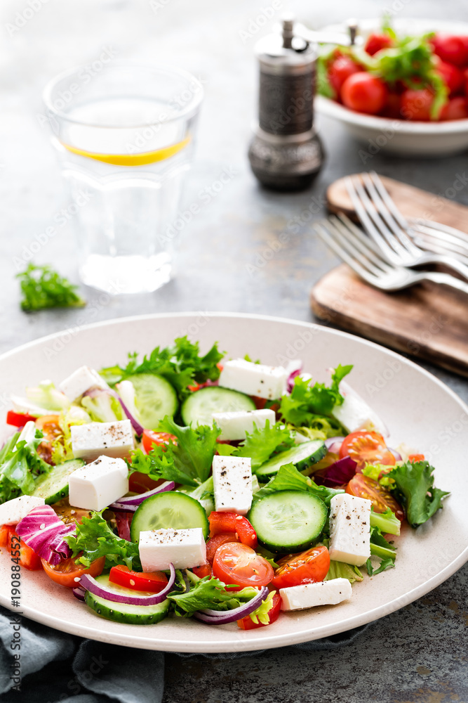 Fresh vegetable salad with feta cheese, fresh lettuce, cherry tomatoes, red onion and pepper