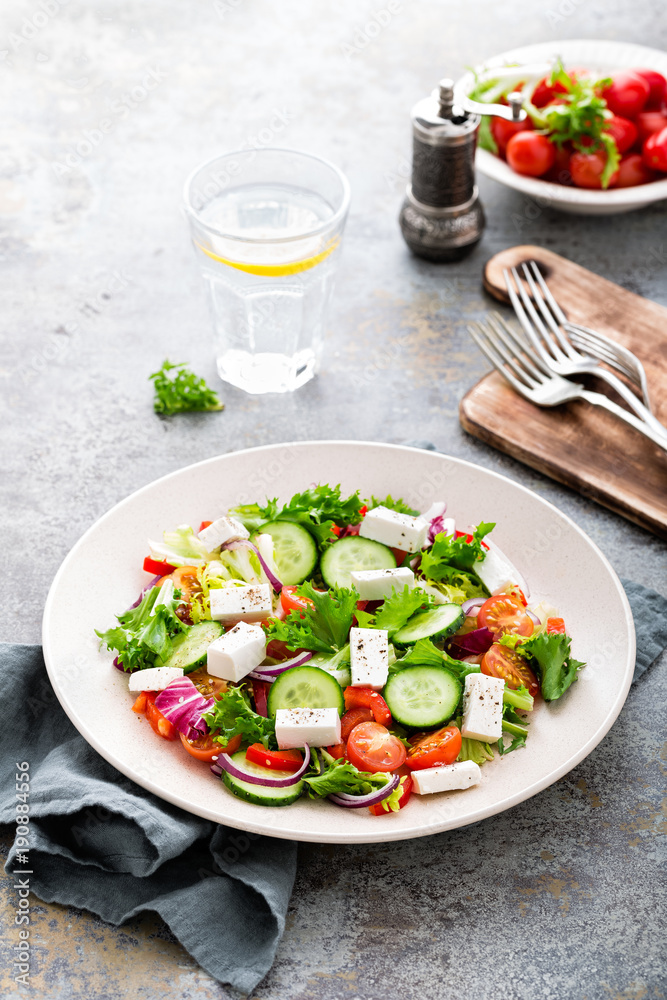 Fresh vegetable salad with feta cheese, fresh lettuce, cherry tomatoes, red onion and pepper