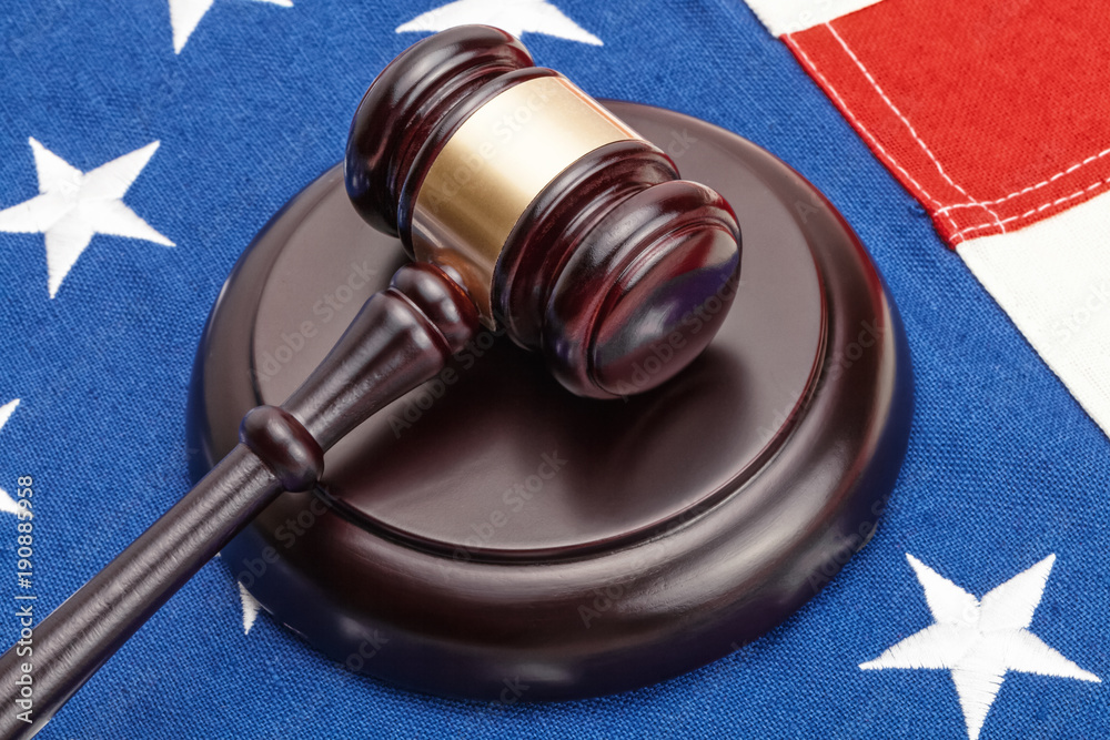 Close up shot of wooden judge gavel over United States flag