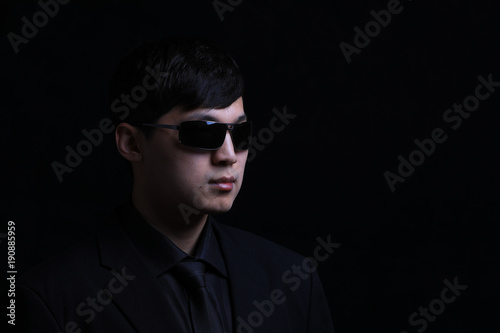 Portrait of a young Asian man. Close-up face on a black background