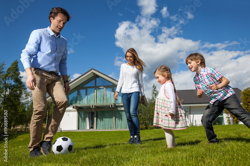 Family playing soccer outside