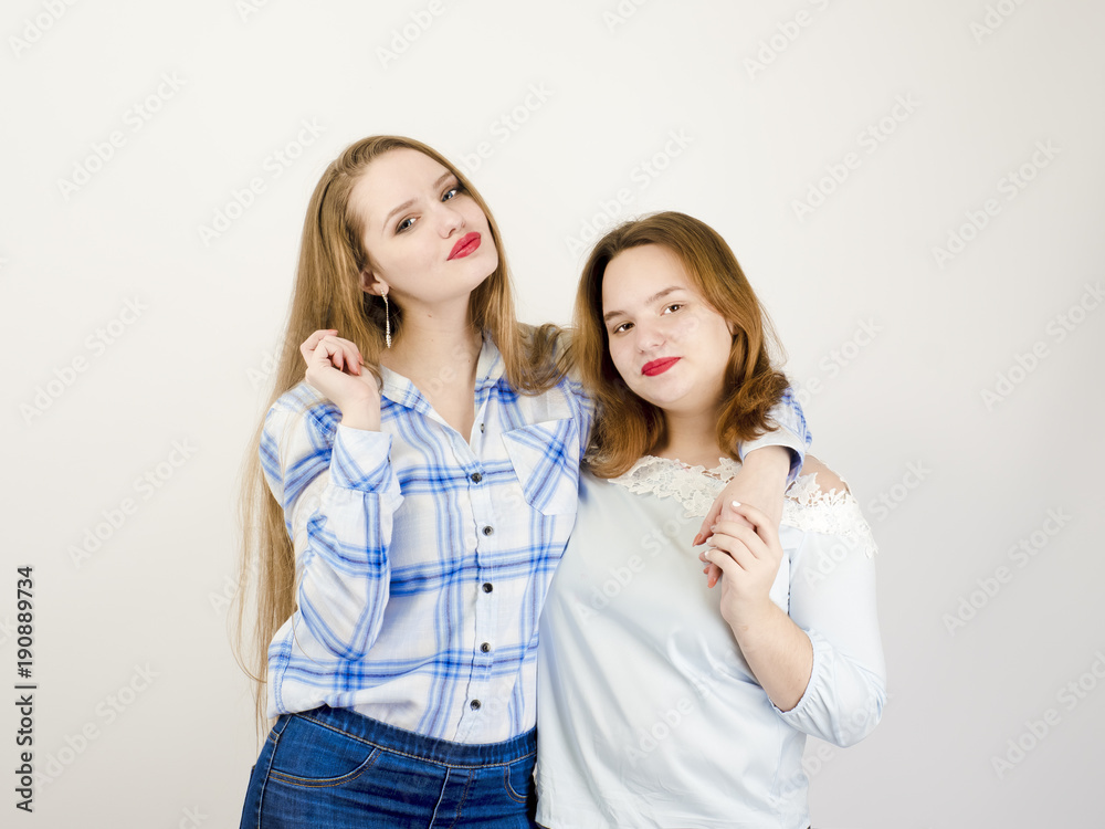 Portrait of two girlfriends girl in casual clothes posing, gray background Portrait of two girlfriends girl in casual clothes posing, gray background