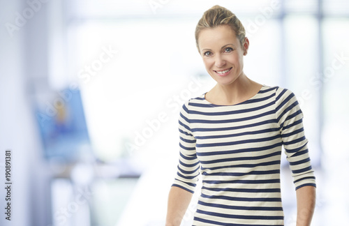 Mature business woman portrait. A confident casual businesswoman standing in the office and smiling to you while looking at the camera. Free Download Mature business woman portrait. A confident casual businesswoman standing in the office and smiling to you while looking at the camera. - GFXLoad