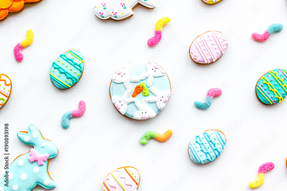 Easter background. Cookies in shape of Easter eggs and Easter bunny. White background top view pattern