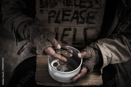 фотографія Homeless hands hold the bowl and count money inside