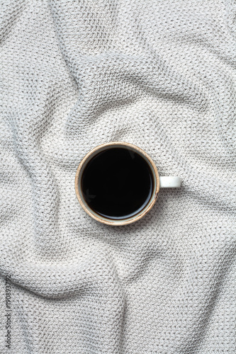 Coffee cup on wool background. Flat lay, top view. sweater knitted texture.