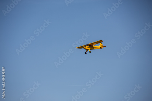 Gelbes Sportflugzeug am strahlend blauen Himmel