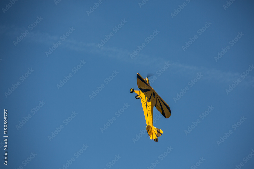 Gelbes Sportflugzeug am strahlend blauen Himmel 