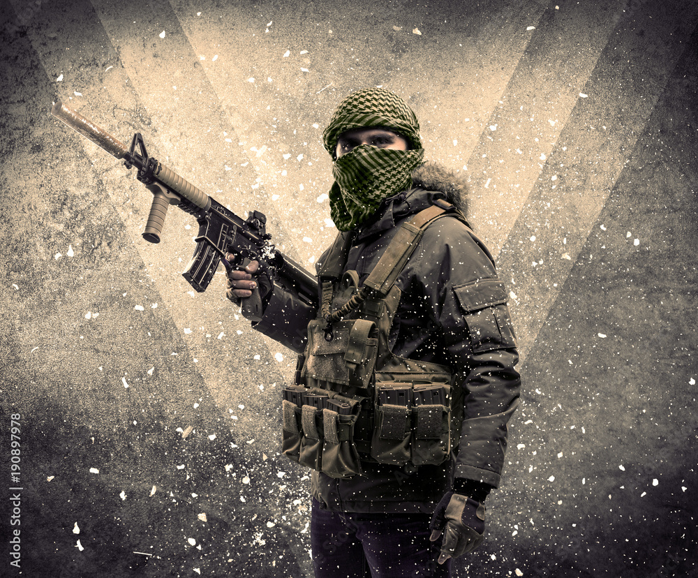 Portrait of a dangerous masked armed soldier with grungy background