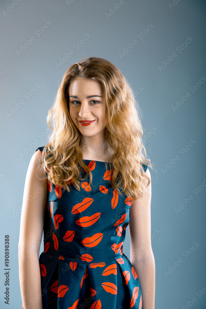 portrait of pretty young girl wearing lips printed dress and lips printed top over grey background portrait of pretty young girl wearing lips printed dress and lips printed top over grey background