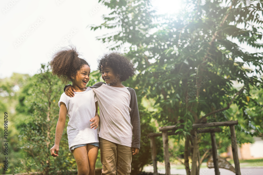 Fototapeta premium Children Friendship Togetherness Smiling Happiness Concept.Cute african american little boy and girl hug each other in summer sunny day