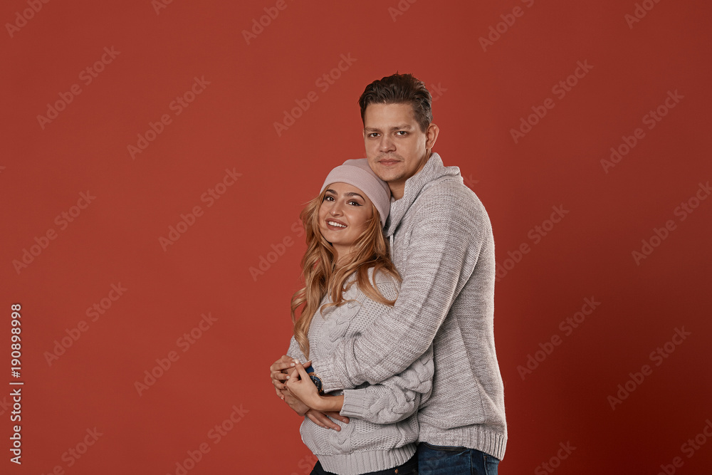 Romantic couple on red background hugging Romantic couple on red background hugging