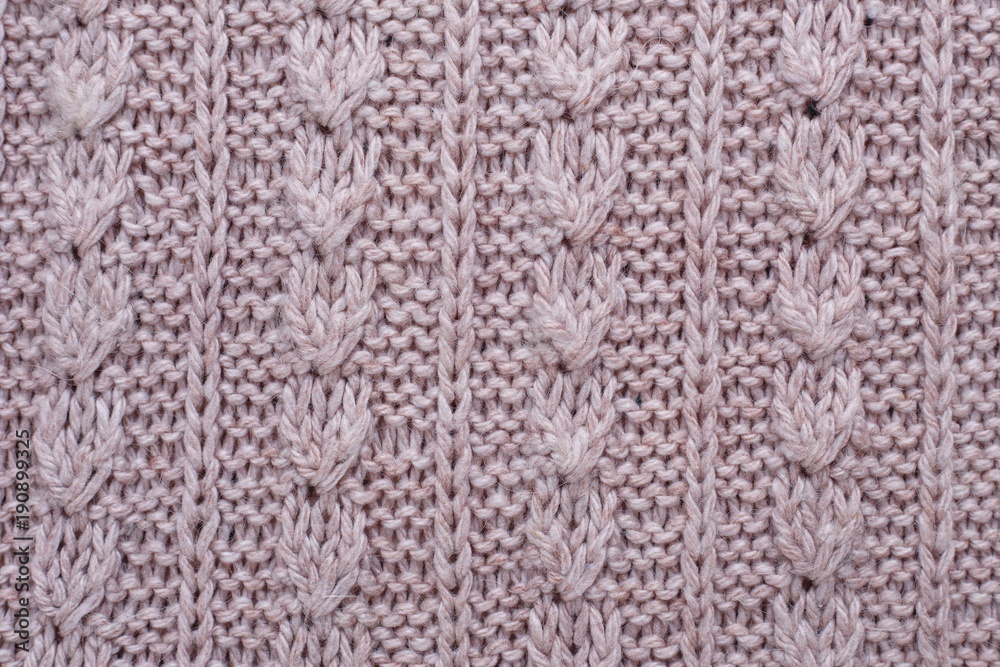 Knitted texture of beige woolen fabric with pattern. Copyspace, background