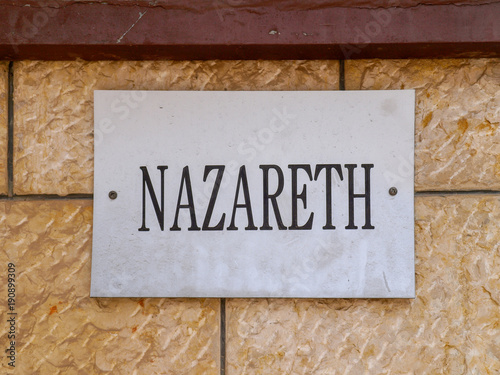 Nazareth sign with black letters on a dirty white board, mounted on a stone wall. photo