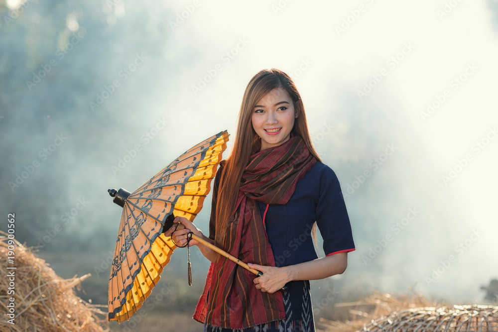 Φωτογραφία Beautiful Thai girl in Thai costume,Asian woman wearing traditional Thai culture with umbrella at farmland