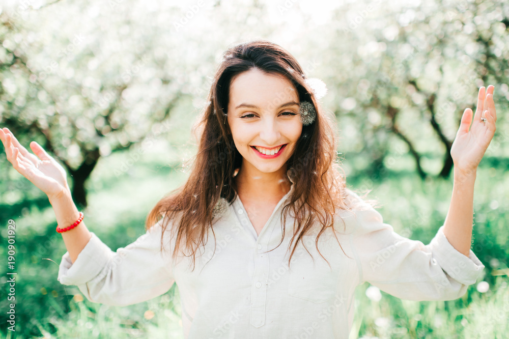 Expressive portrait of young cheerful emotional model girl throwing hair. Spring is coming. Cute funny unusual female person enjoying innocence of life outdoor in blooming garden with blossom flowers. Expressive portrait of young cheerful emotional model girl throwing hair. Spring is coming. Cute funny unusual female person enjoying innocence of life outdoor in blooming garden with blossom flowers.