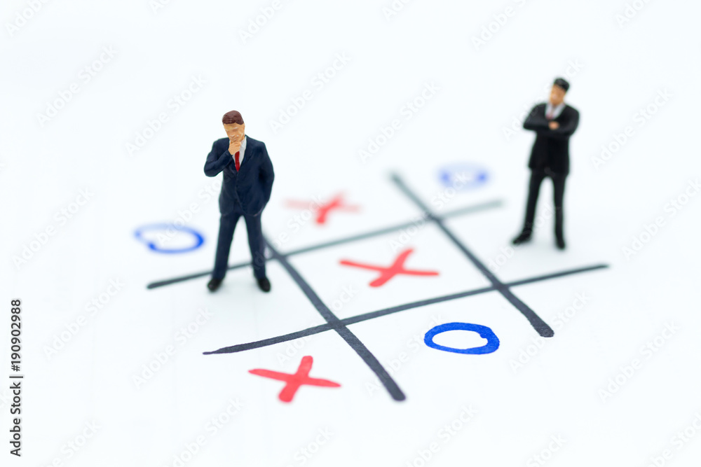 Miniature people: Businessmen stand on XO game board. Image use for business competition concept. Miniature people: Businessmen stand on XO game board. Image use for business competition concept.