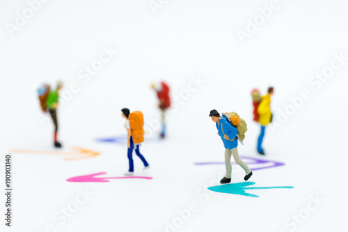 Miniature people : Backpacker group walking follow arrow. Image use for travel, business concept.