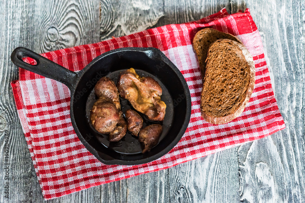 Ταπετσαρία Top view roasted chicken giblets in pan and bread