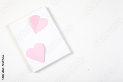 Origami paper heart pink color on white background.