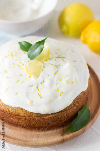 Lemon cake with whipped cream on a light background.