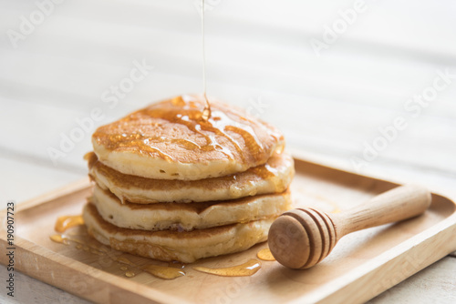 pancake with honey on wood plate