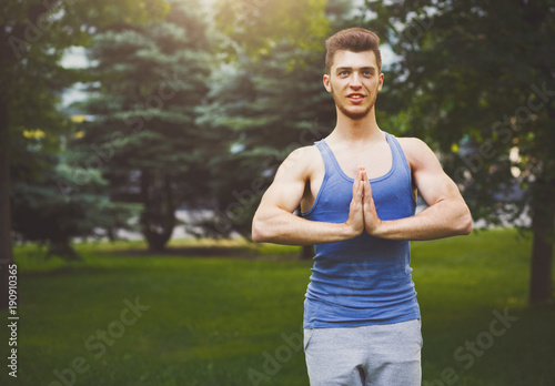 Meditating man with praying hands outdoors